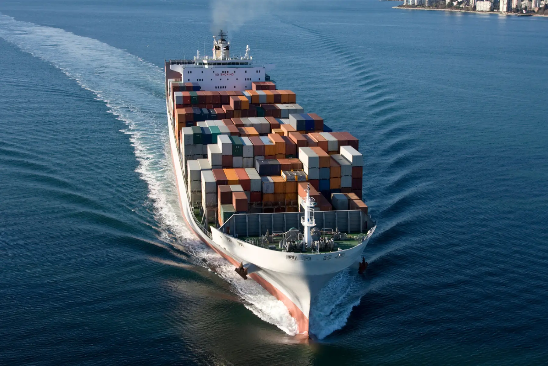 Cargo ship filled with shipping containers travelling through the water
